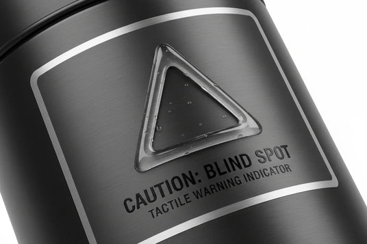 “Close-up of a premium product label with a raised tactile warning triangle applied in varnish for safety compliance.”